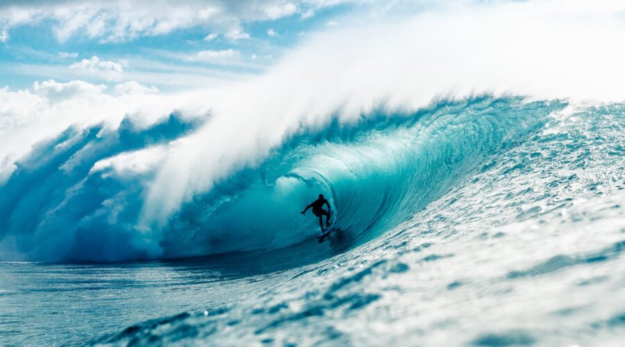 man riding surfboard in wavy ocean