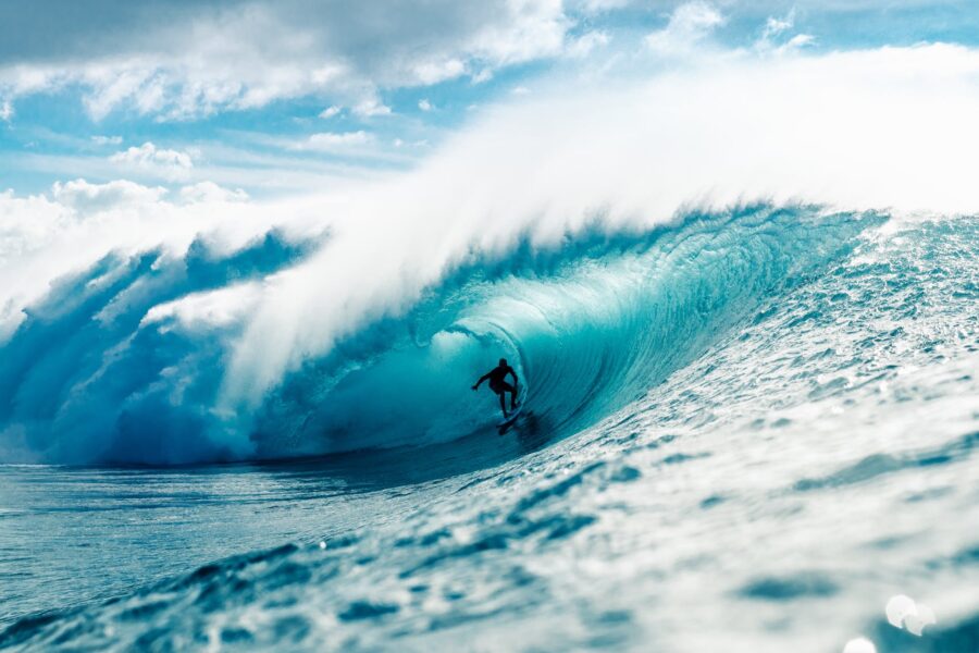 man riding surfboard in wavy ocean