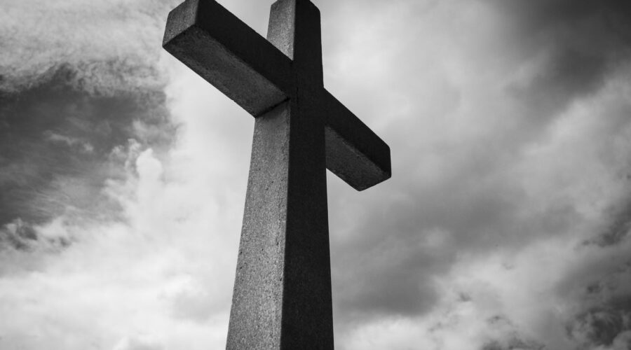 low angle photo of concrete cross under clouds