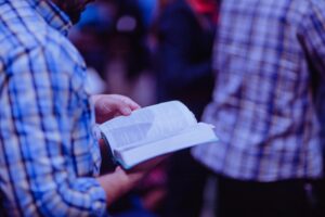 person reading the bible while standing