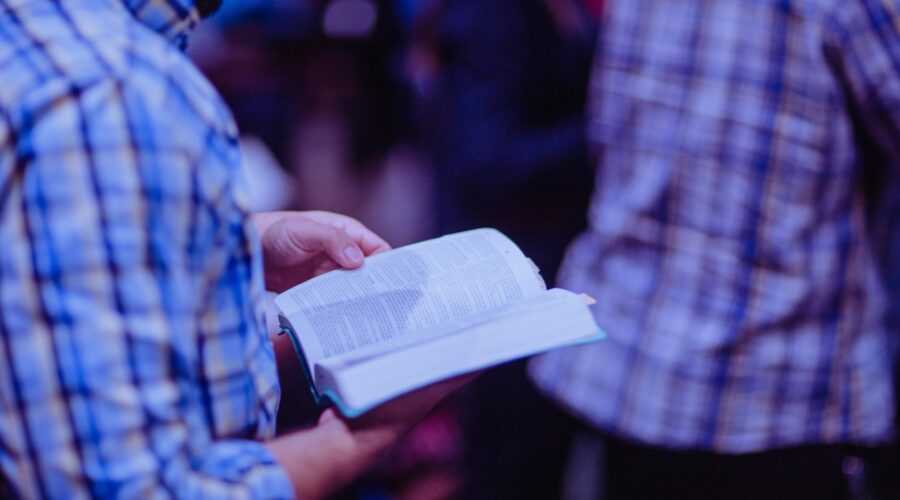 person reading the bible while standing