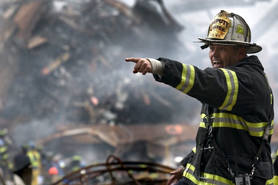 fire fighter wearing black and yellow uniform pointing for something