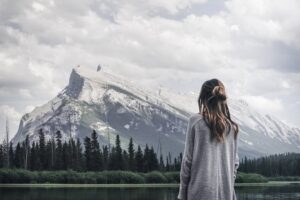 woman standing near rock in front of lake