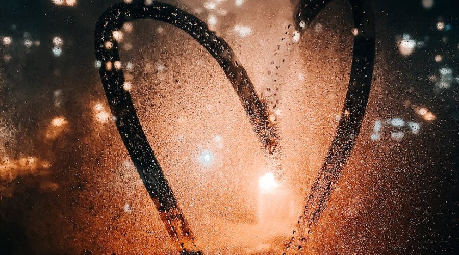 heart drawn on glass of wet window