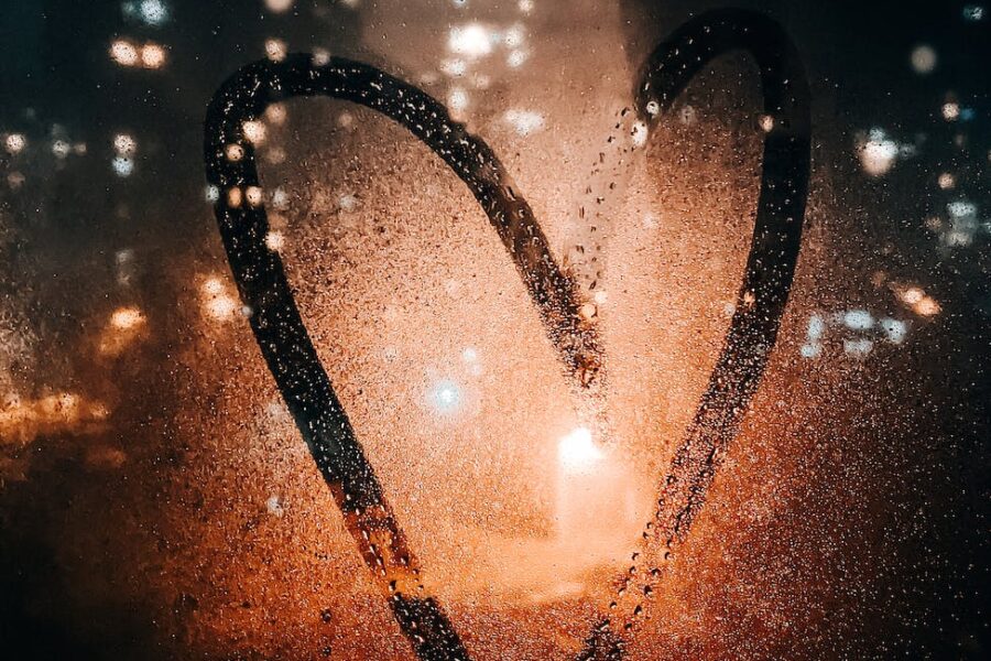 heart drawn on glass of wet window