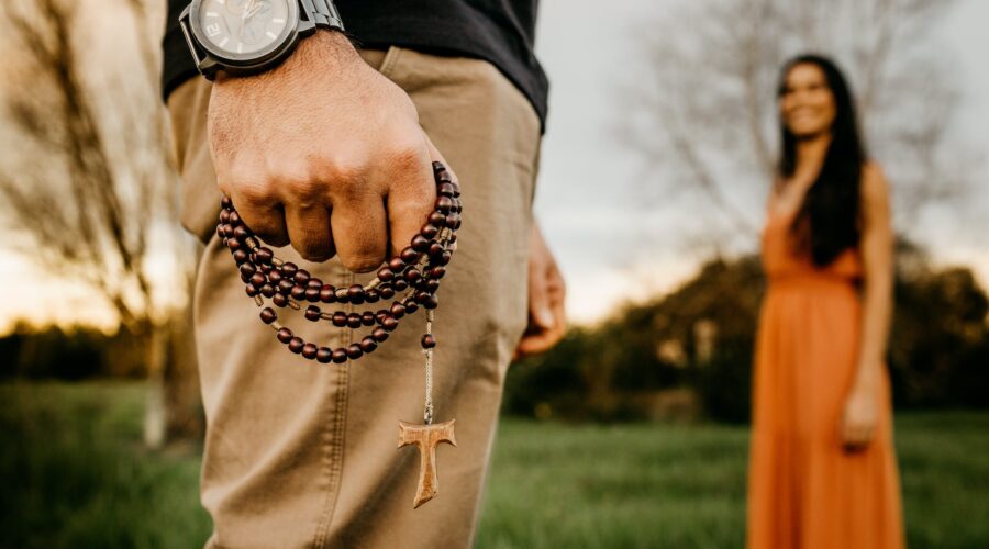 unrecognizable man with prayer beads standing in park near woman