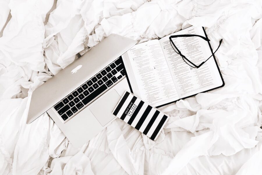 eyeglasses on book beside macbook